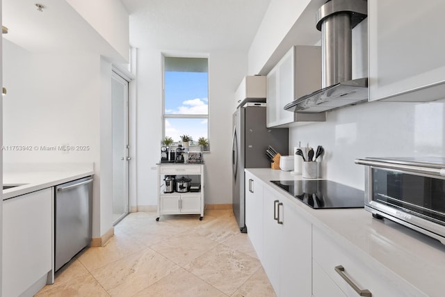 kitchen with white cabinets, wall chimney range hood, stainless steel appliances, and light countertops