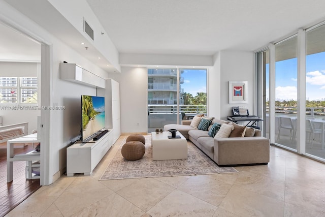 living room featuring a wall of windows, a healthy amount of sunlight, and visible vents