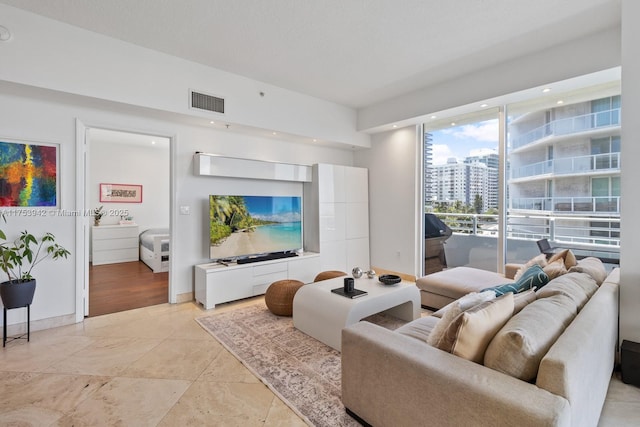 living area with baseboards and visible vents