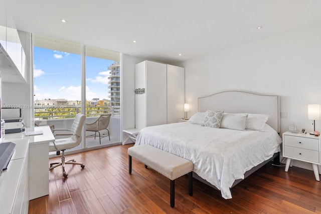 bedroom with access to exterior, recessed lighting, floor to ceiling windows, and dark wood finished floors