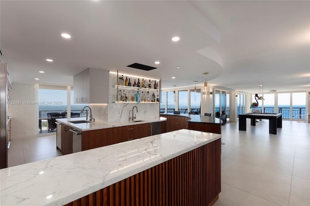 kitchen with tasteful backsplash, a kitchen island, a sink, and modern cabinets