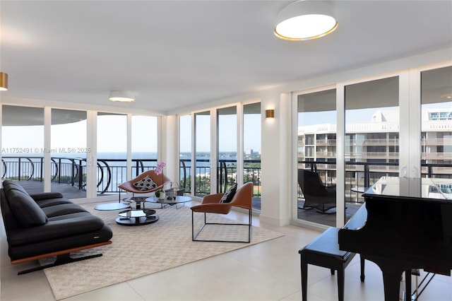 living area featuring expansive windows, a healthy amount of sunlight, and a water view