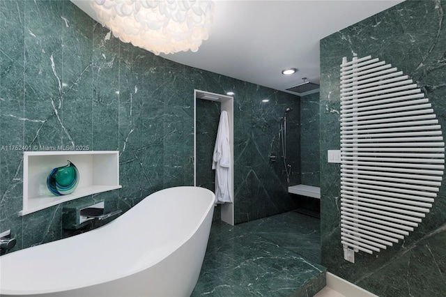bathroom featuring marble finish floor, walk in shower, a freestanding tub, tile walls, and recessed lighting