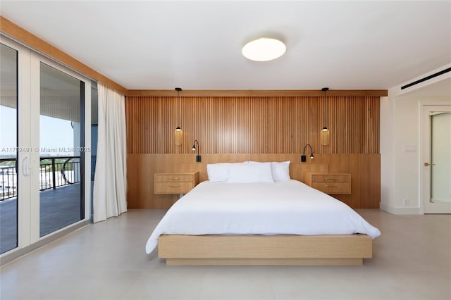 bedroom with access to exterior and wooden walls