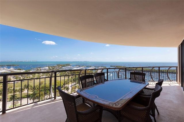 balcony featuring outdoor dining area and a water view
