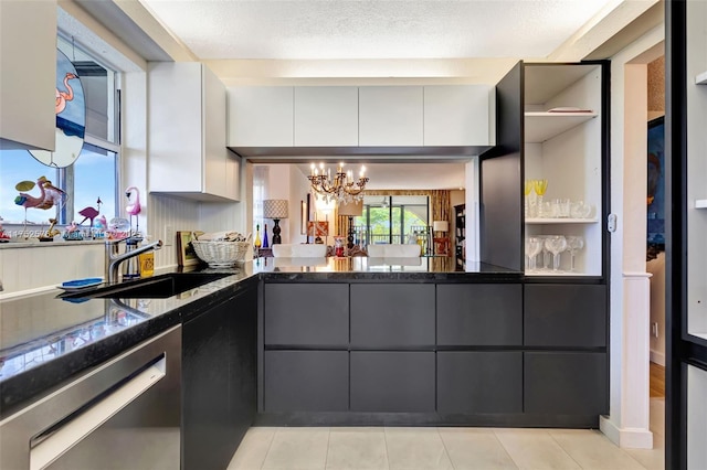 kitchen with white cabinetry, a sink, a textured ceiling, a chandelier, and dishwasher