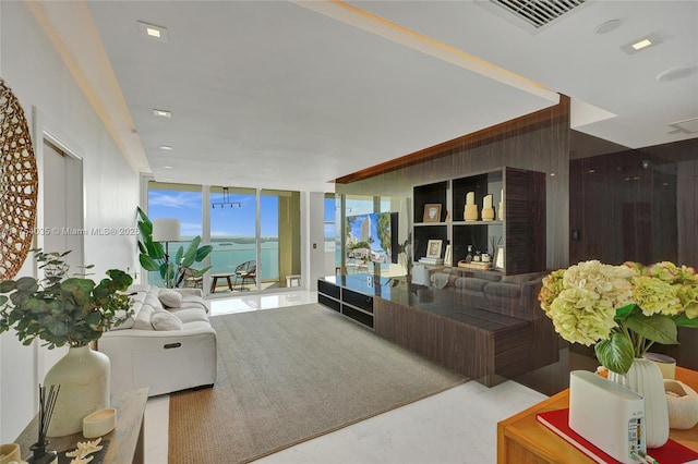 living room featuring wood walls, a wall of windows, and visible vents