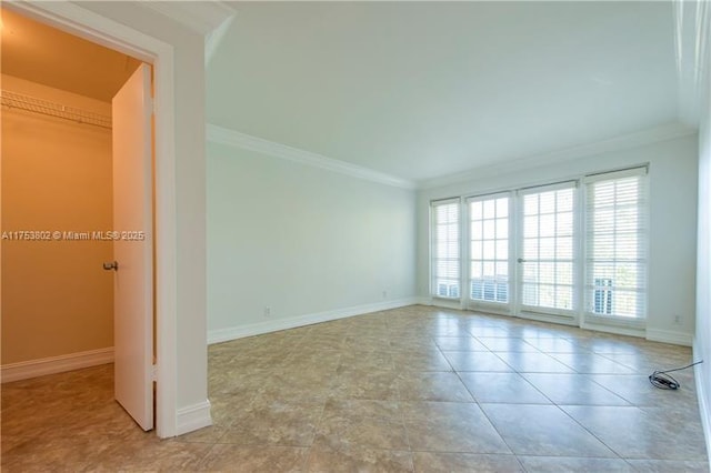 tiled spare room with ornamental molding and baseboards