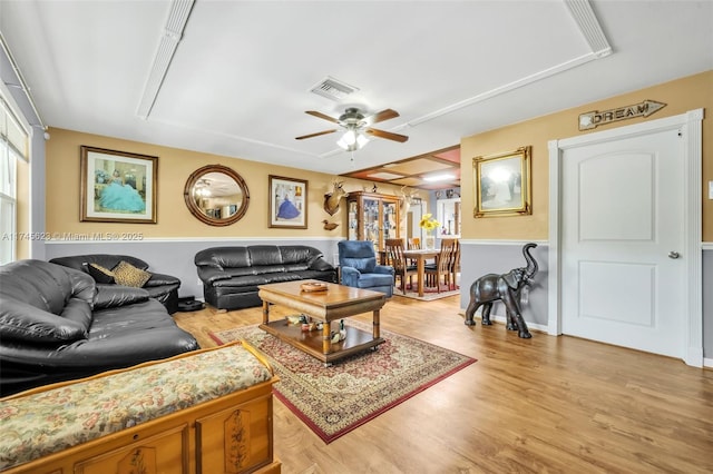 living area with ceiling fan, light wood-style flooring, and visible vents