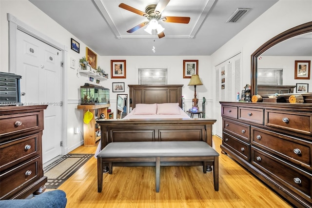 bedroom featuring arched walkways, a closet, visible vents, ceiling fan, and light wood-type flooring