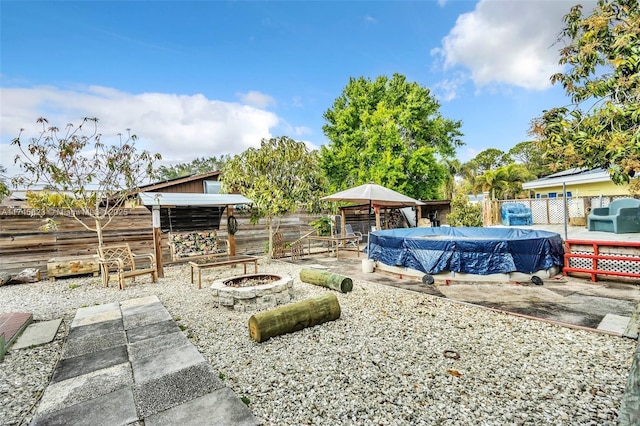 view of yard featuring a fenced backyard, a fire pit, a fenced in pool, and a patio