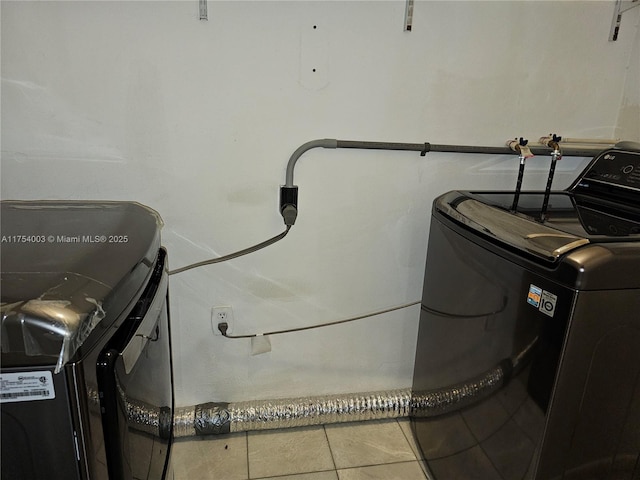 washroom featuring laundry area, tile patterned flooring, and washer and clothes dryer