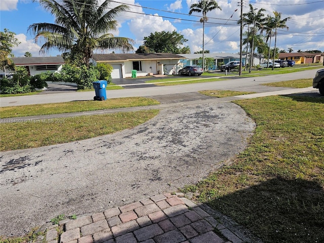 view of yard featuring driveway and a garage