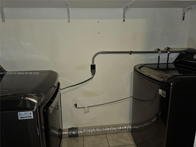 laundry area featuring tile patterned flooring, laundry area, and washing machine and clothes dryer