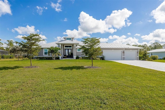 view of front of house featuring decorative driveway, an attached garage, a standing seam roof, metal roof, and a front lawn