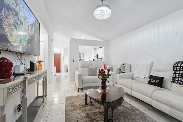 living area featuring vaulted ceiling, a textured ceiling, and light tile patterned floors