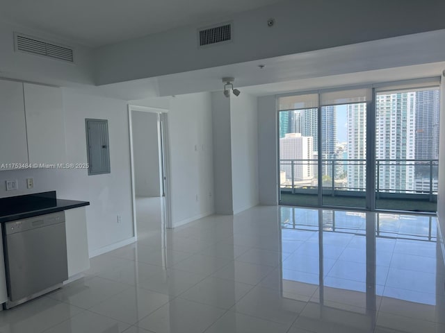 spare room featuring light tile patterned floors, baseboards, electric panel, and visible vents