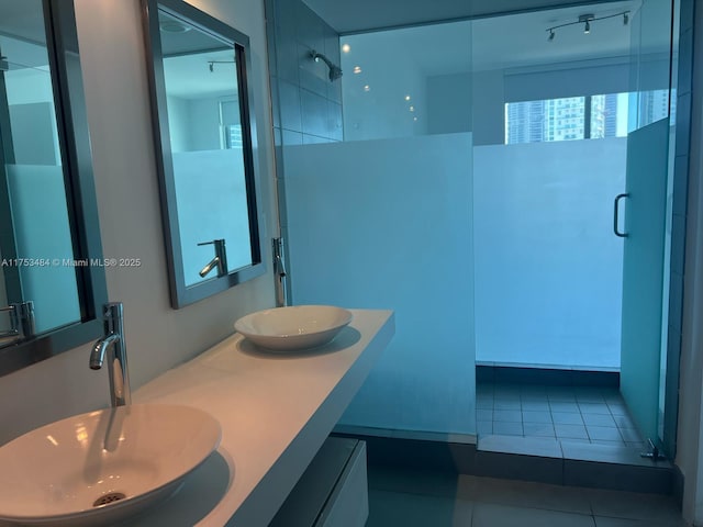 full bathroom with tile patterned flooring, double vanity, a sink, and walk in shower