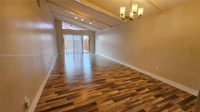 spare room with a chandelier, dark wood finished floors, vaulted ceiling with beams, and baseboards