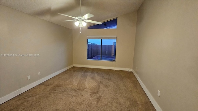 spare room featuring lofted ceiling, carpet, baseboards, and ceiling fan