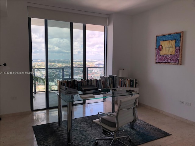 office space with a wealth of natural light, floor to ceiling windows, and baseboards