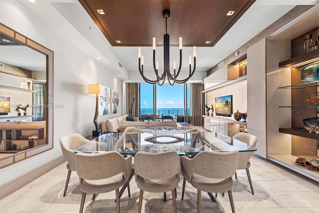 dining space with an inviting chandelier, visible vents, and a raised ceiling