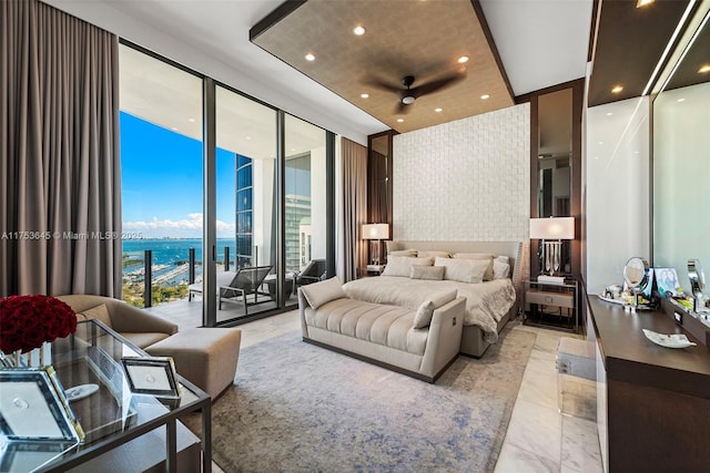 bedroom with a water view, access to exterior, a wall of windows, and recessed lighting