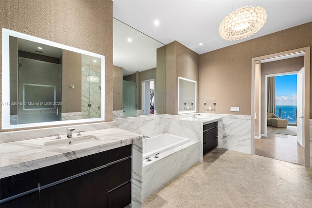 full bathroom with two vanities, a sink, a bath, and a shower stall