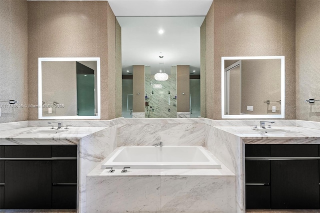 full bath with two vanities, a sink, a shower stall, and a garden tub