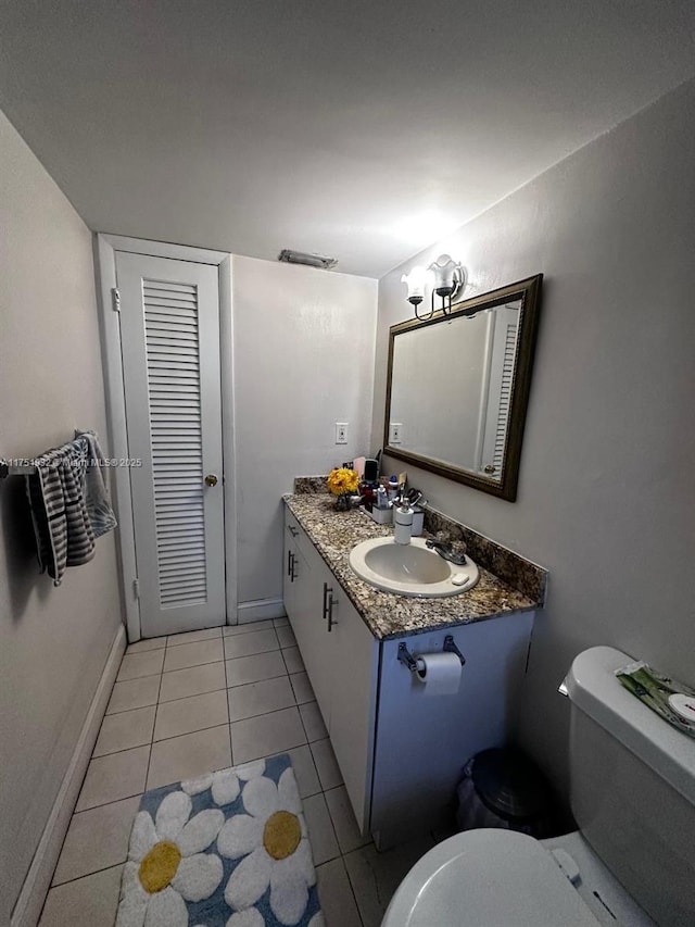 half bath featuring baseboards, visible vents, toilet, tile patterned floors, and vanity