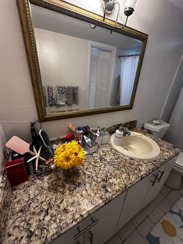 full bathroom with vanity, tile patterned flooring, and toilet