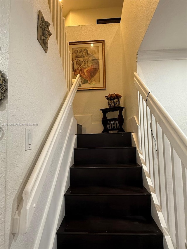 staircase with a textured wall