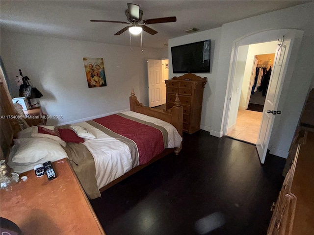 bedroom featuring arched walkways, visible vents, ceiling fan, and baseboards