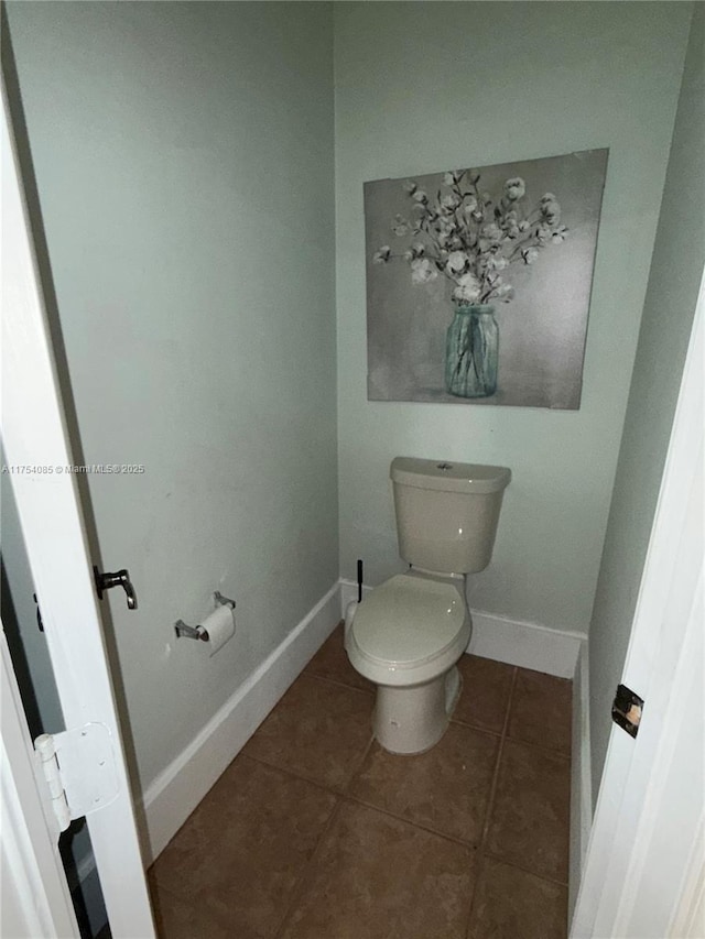 bathroom featuring tile patterned flooring, toilet, and baseboards