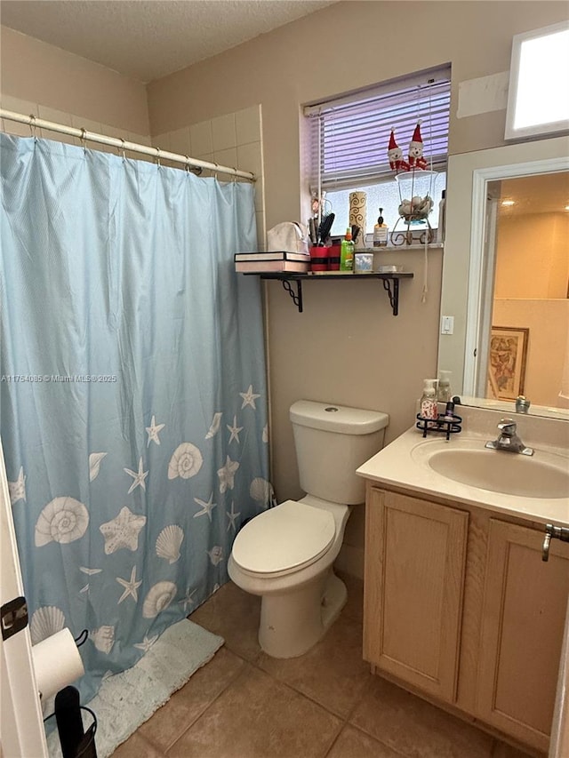 bathroom featuring curtained shower, toilet, vanity, a textured ceiling, and tile patterned floors