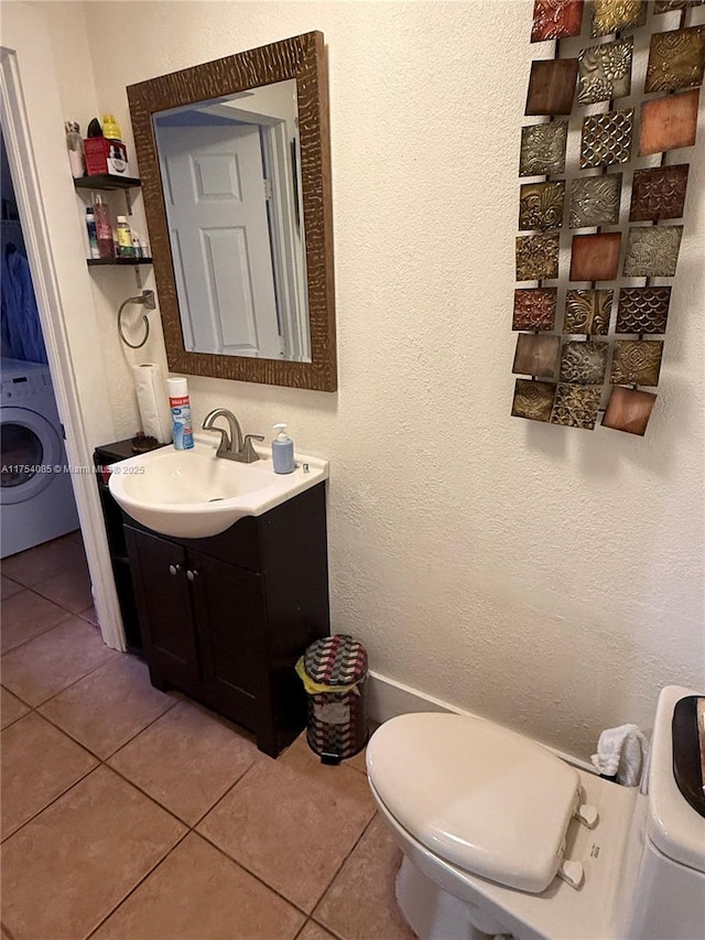 bathroom featuring washer / clothes dryer, tile patterned flooring, and toilet