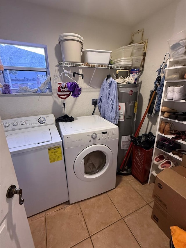 washroom with water heater, laundry area, light tile patterned floors, and washer and clothes dryer