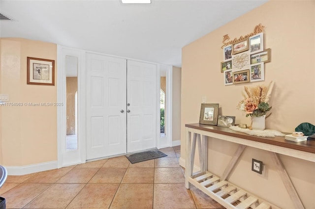 entrance foyer with light tile patterned floors, visible vents, and baseboards