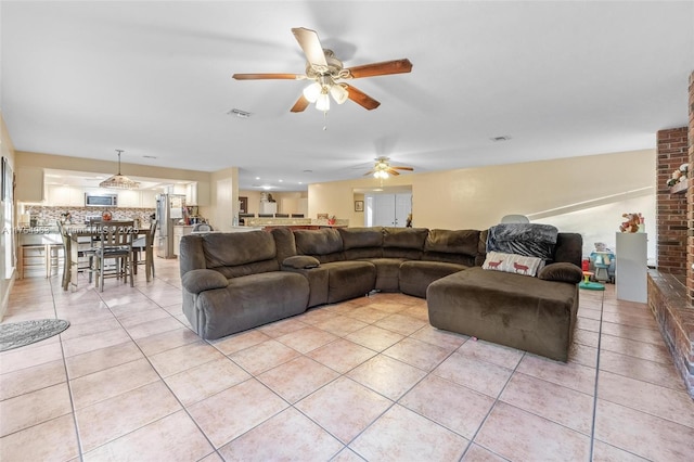 living room with light tile patterned flooring, ceiling fan, and visible vents