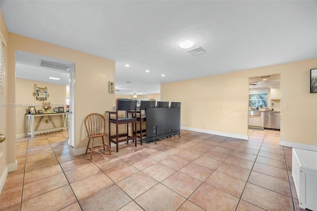 kitchen featuring baseboards, visible vents, stainless steel dishwasher, and light tile patterned floors