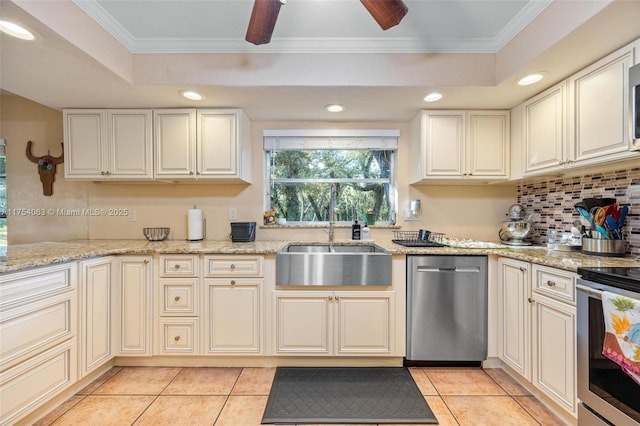 kitchen with a tray ceiling, stainless steel appliances, recessed lighting, ornamental molding, and a sink