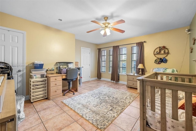 bedroom with light tile patterned floors, ceiling fan, and baseboards