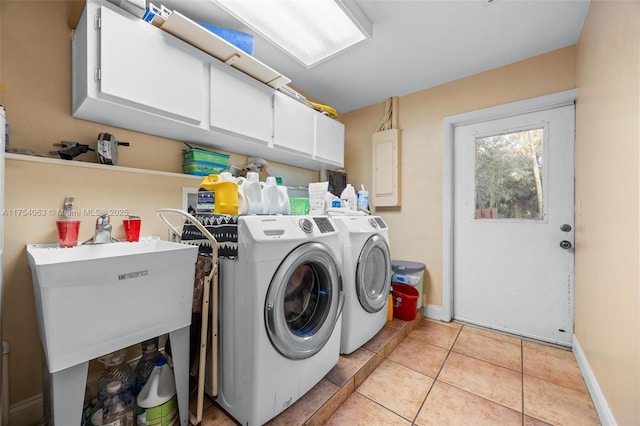 clothes washing area featuring cabinet space, light tile patterned floors, electric panel, washer and clothes dryer, and a sink