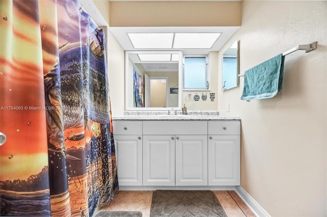 bathroom featuring vanity, baseboards, and tile patterned floors