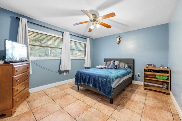 bedroom featuring a ceiling fan, baseboards, and light tile patterned floors