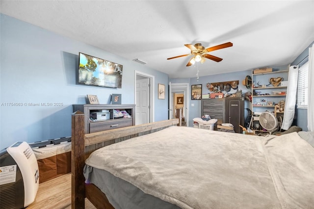 bedroom featuring visible vents, ceiling fan, and wood finished floors