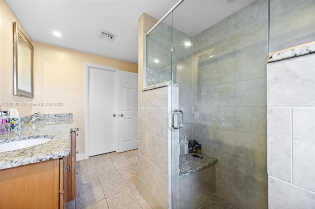 full bath with double vanity, visible vents, tile patterned flooring, a shower stall, and a sink