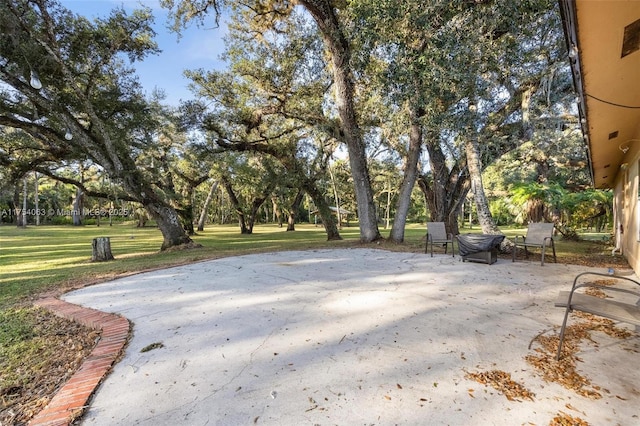 view of property's community featuring a patio area and a lawn