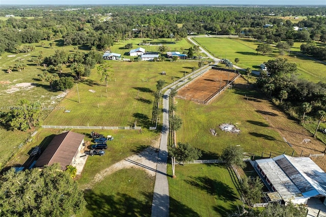 birds eye view of property featuring a rural view and a wooded view