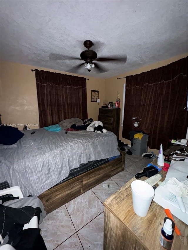 bedroom featuring a ceiling fan and a textured ceiling